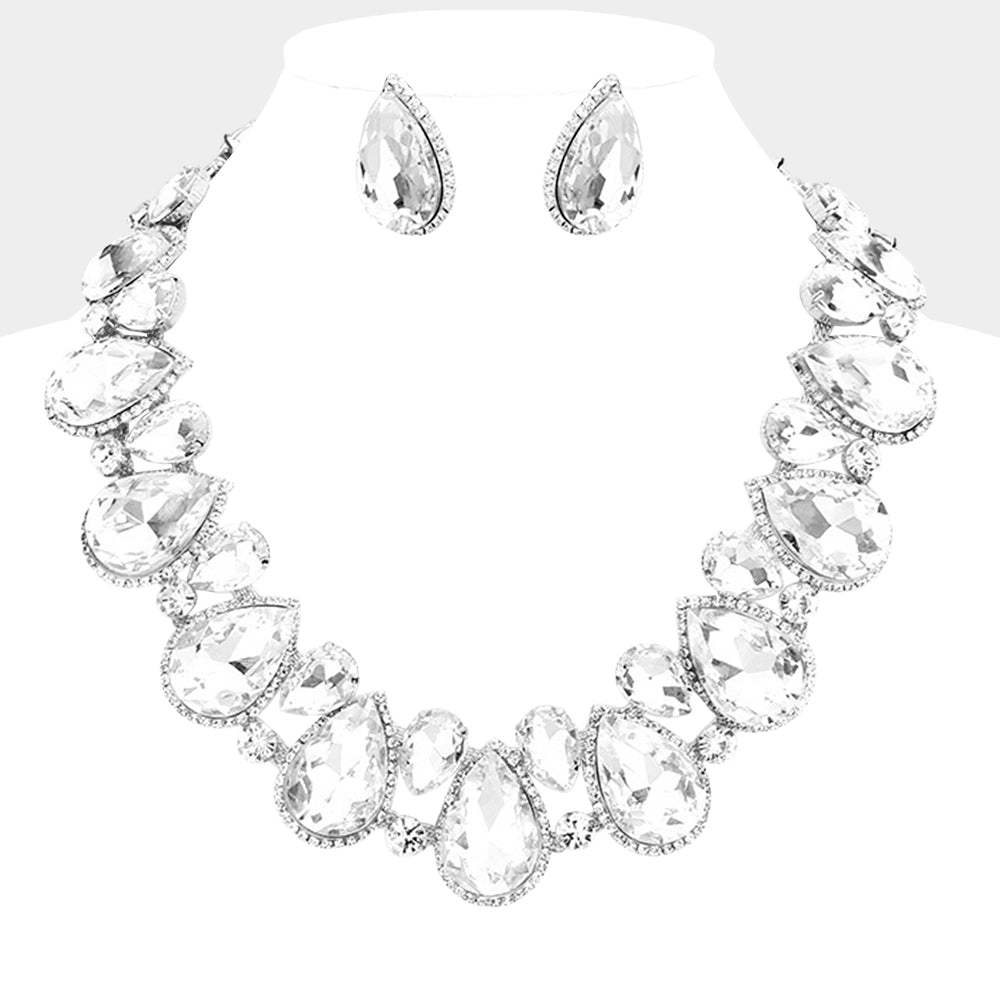Clear teardrop crystal prom necklace set with matching earrings on a white bust on a gray background