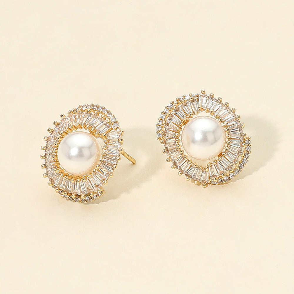 Cream pearl CZ halo bridal stud earrings in a 14K gold dipped setting on a beige background