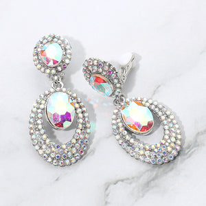 AB stone oval double-halo crystal clip-on earrings on silver on a white marble background — 2.1" silver statement drops for evening or pageant glam.
