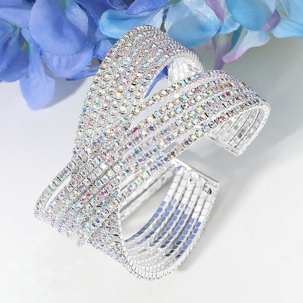 Silver bracelet with crystal embellishments on a white background with blue flowers.