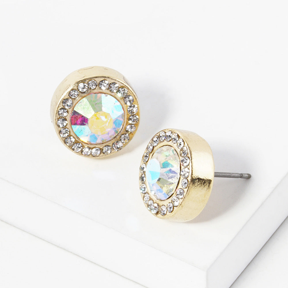 A pair of gold stud earrings with an oval AB faceted center stone surrounded by a halo of small clear rhinestones, displayed on a clean white surface.