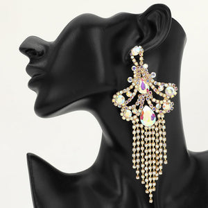 A large ornate AB crystal statement earring on gold with cascading bead fringe and iridescent crystal accents on a black earring mannequin.
