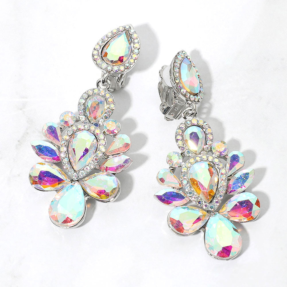 Silver-tone chandelier clip-on earrings with AB teardrop and oval faceted crystals surrounded by smaller clear rhinestones, displayed on a white marble surface.