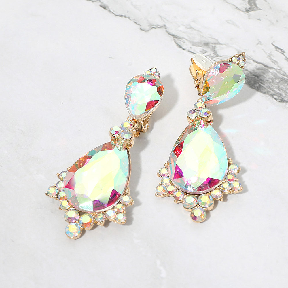 AB faceted teardrop clip-on statement earrings on gold on a white marble background