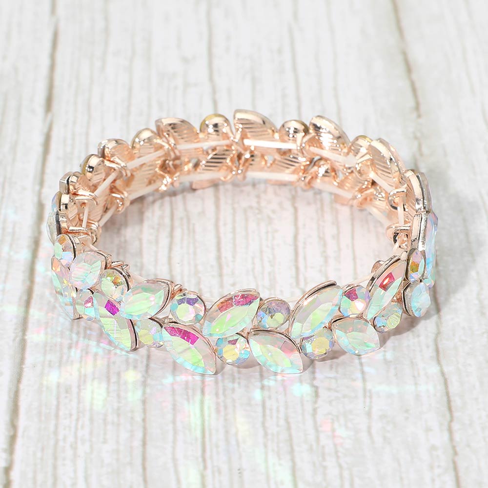 AB marquise and round stone cluster stretch bracelet on rose gold with iridescent stones on a light wood background
