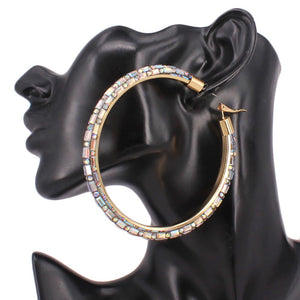 Oversized AB baguette rhinestone hoop earrings on gold with omega back 3.5 inch diameter shown on a black mannequin ear