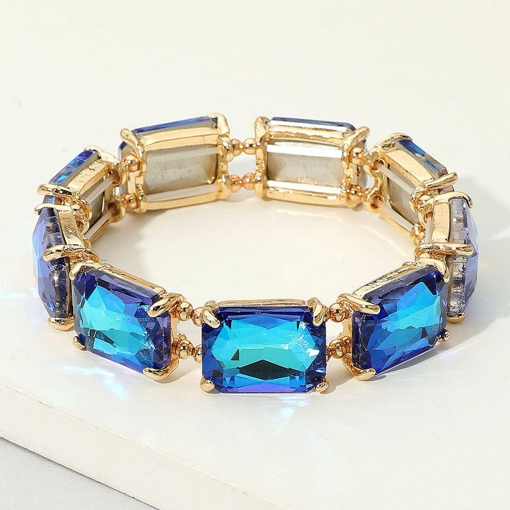 Gold bracelet with blue gemstones on a white surface