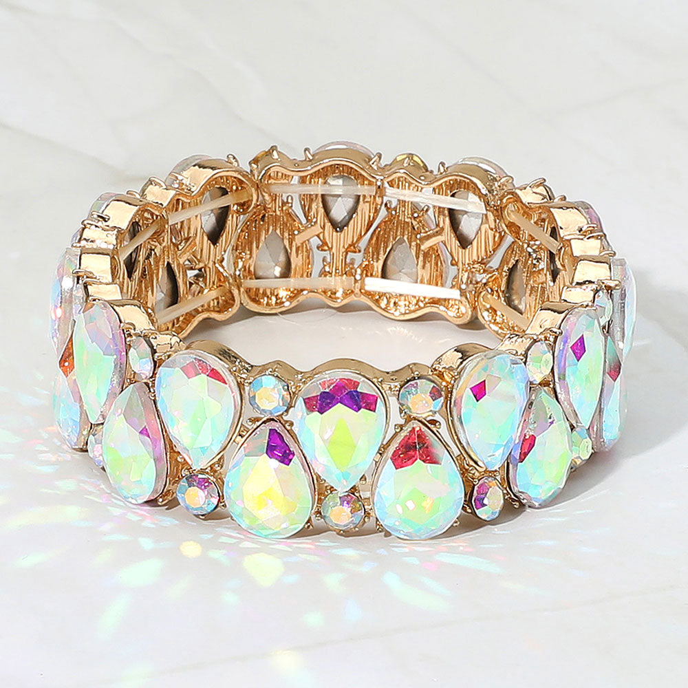 AB teardrop and round stone cluster stretch bracelet on gold on white marble background