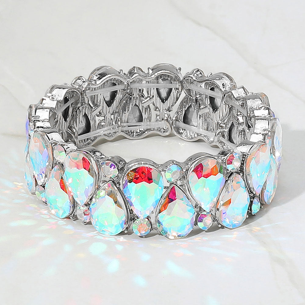 AB teardrop and round stone cluster stretch bracelet on silver on white marble background