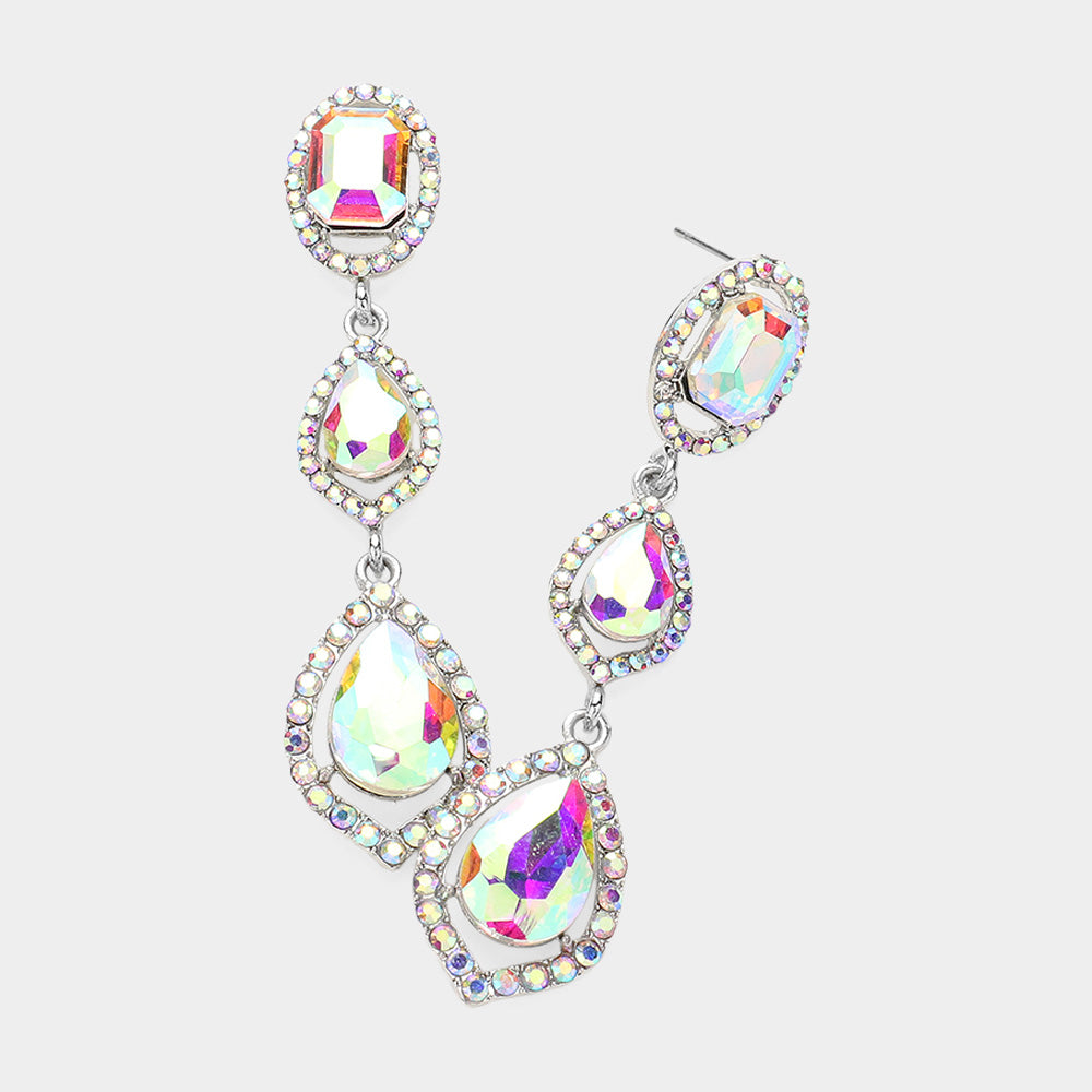 Pair of silver-tone drop earrings featuring large clear oval and pear-shaped crystals surrounded by small clear stones on a light gray background.