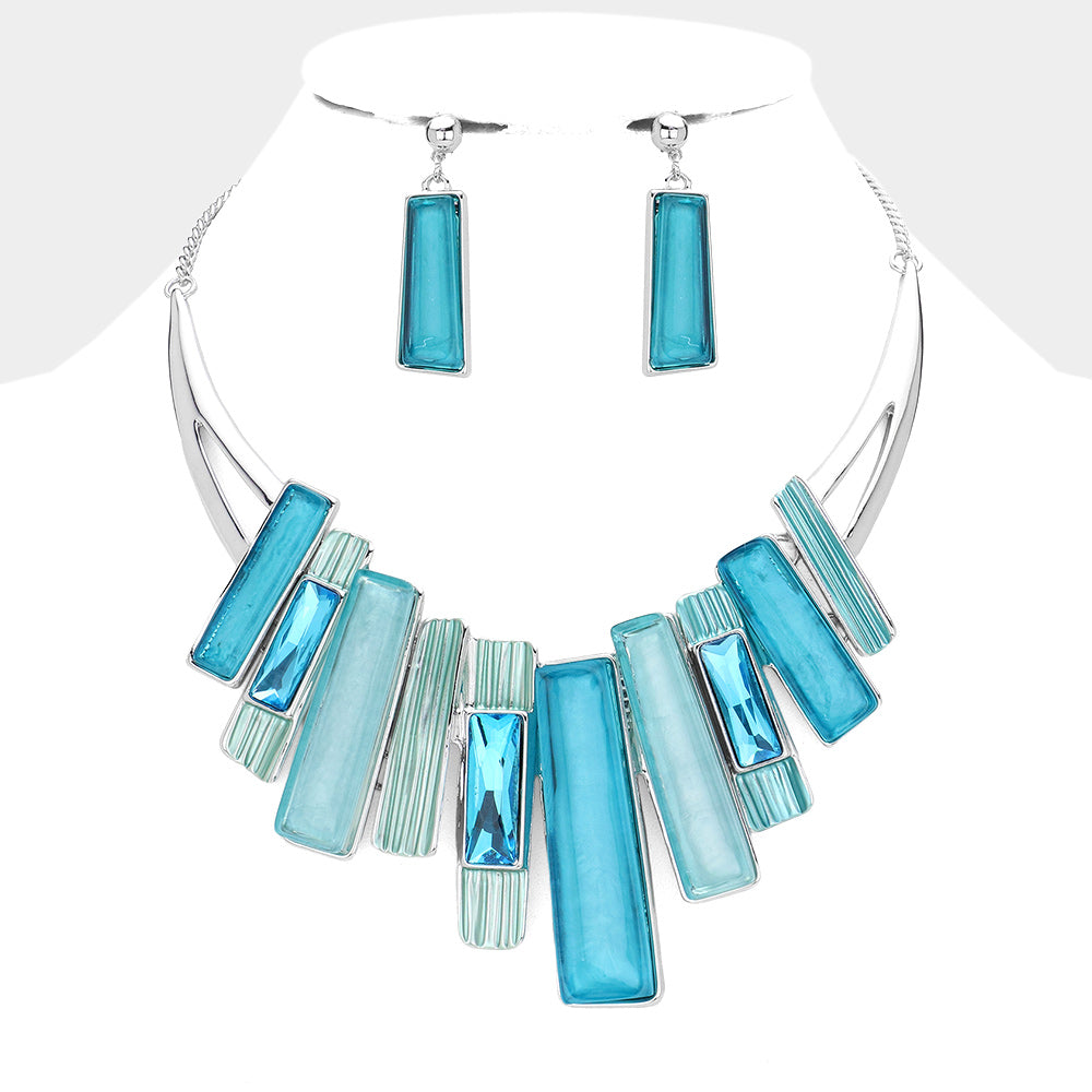 Aqua blue and silver geometric statement necklace and earring set styled for evening or party wear on a white background