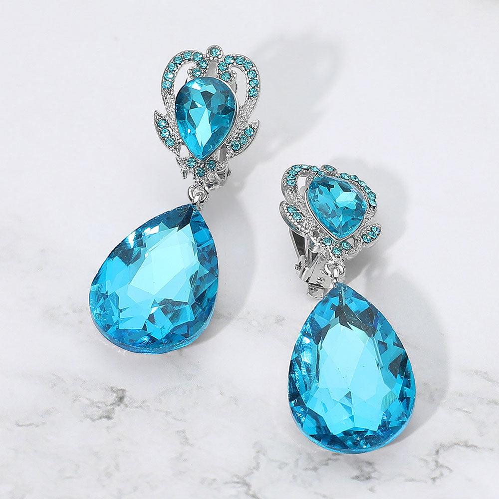 Aqua faceted teardrop stone clip-on earrings on silver. Top stone is elegantly surrounded by aqua  rhinestones in a flower like setting. 

