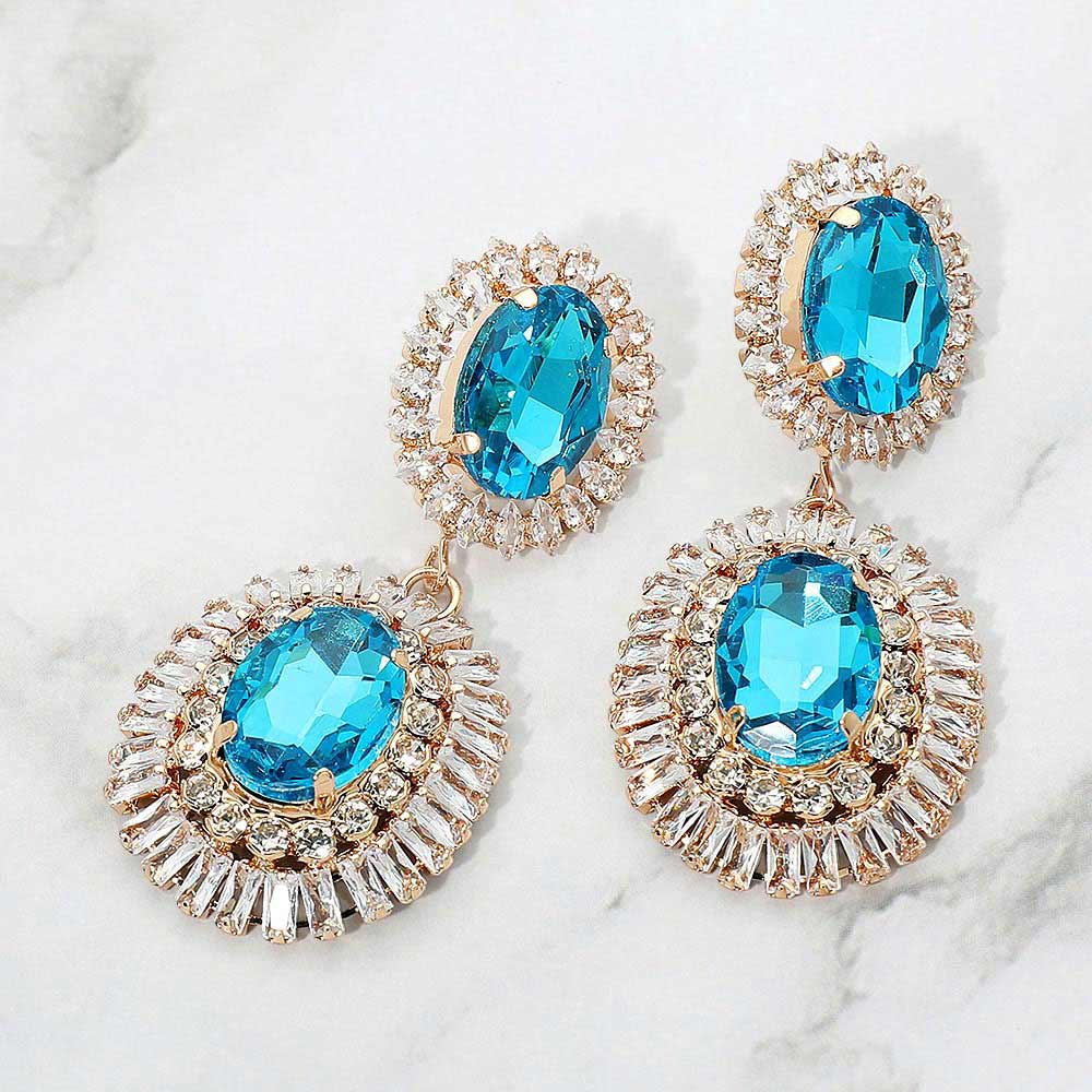 Aqua vintage double oval crystal statement earrings in a gold finish featuring two oval aqua crystals surrounded by sparkling crystal halos, displayed on a white marble background.
