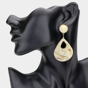 Ivory resin teardrop cutout dangle earrings on a black mannequin ear on a white background— bold modern 3.25" fashion statement jewelry.