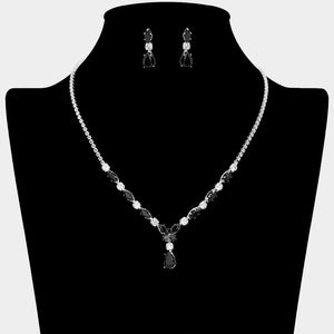 Black and clear crystal dainty necklace set on silver with spaced crystal accents, a delicate center drop, and matching drop earrings, displayed on a black jewelry bust.