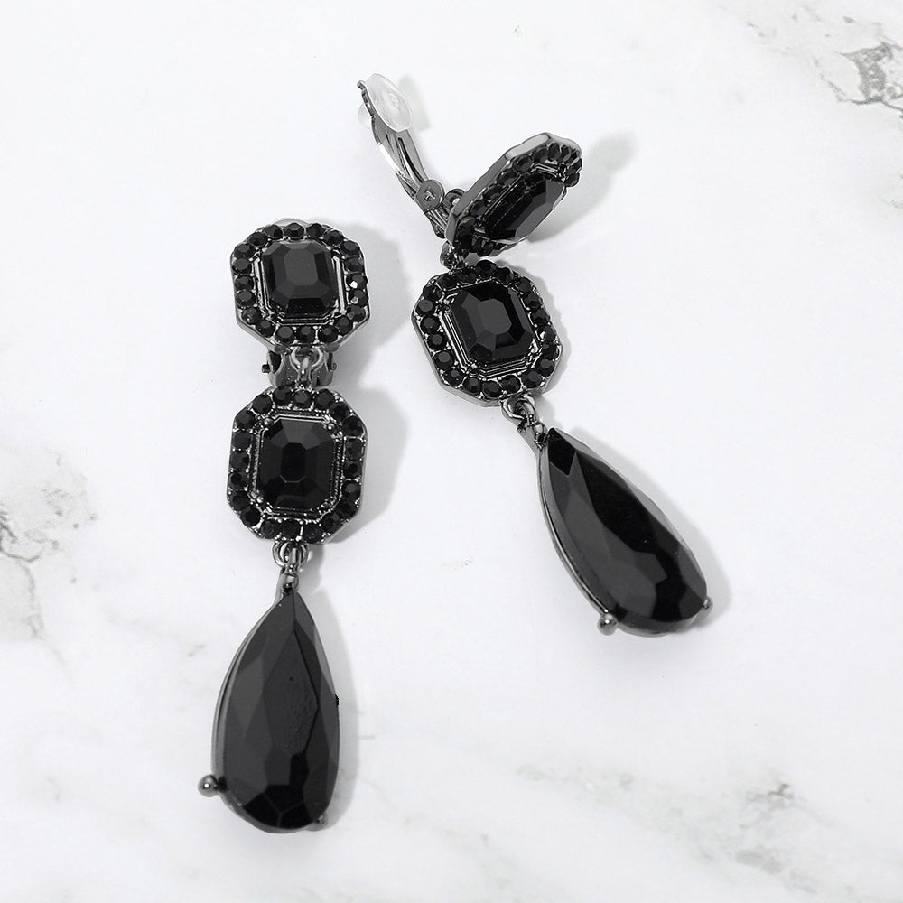Black crystal square and teardrop clip-on earrings on gunmetal-tone metal, displayed against a white background.