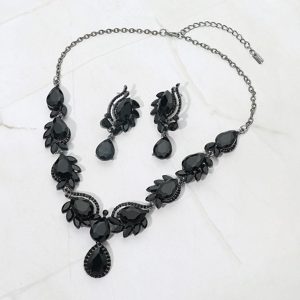 Black teardrop formal necklace and matching earrings set on silver displayed on a white background.