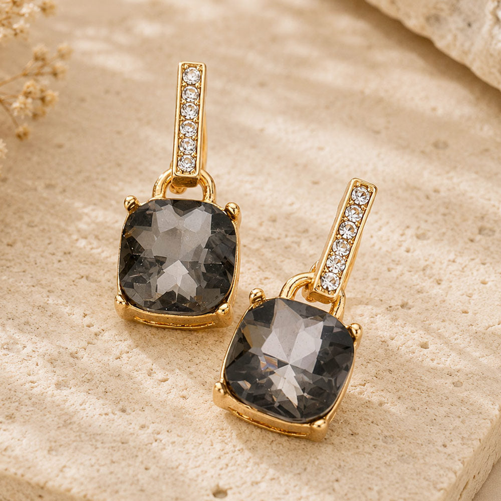 Smoky Grey crystal cushion square dangle earrings on gold with a large cushion-cut stone suspended from a narrow crystal-lined bar, displayed on a white background.