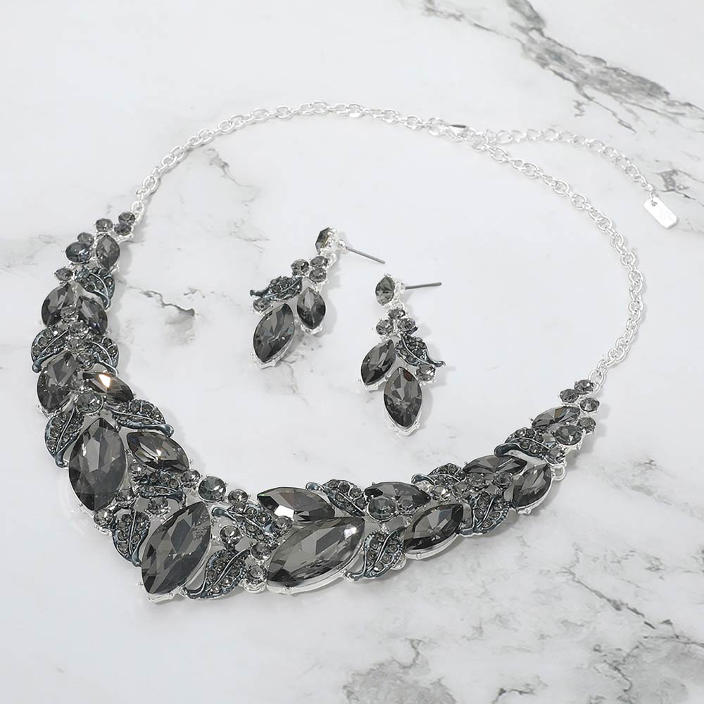 Smoky grey marquise leaf crystal necklace set on silver with matching earrings, dramatic statement jewelry for prom and evening wear on a marble background