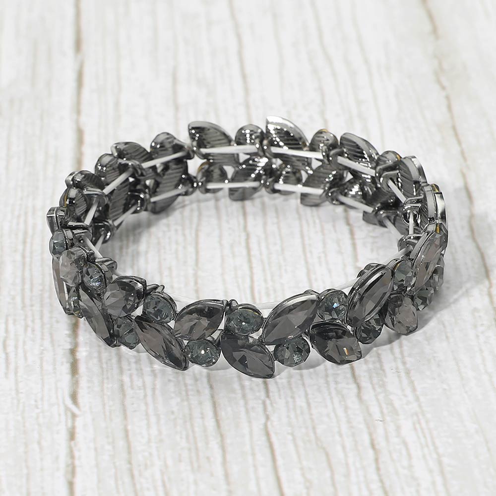 Smoky grey marquise and round stone cluster stretch bracelet on a white wood grain background