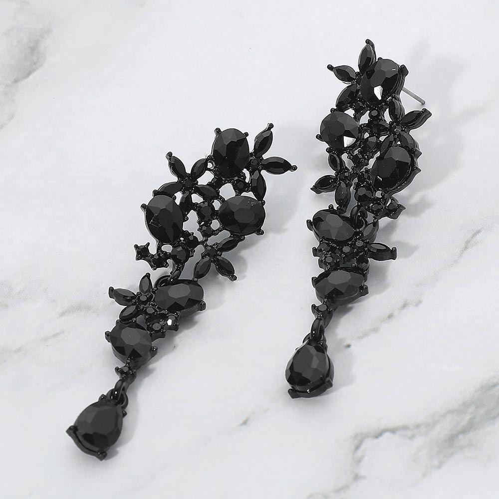 Black floral crystal cluster drop earrings with marquise and oval stones for interviews or evening glam on a marble background