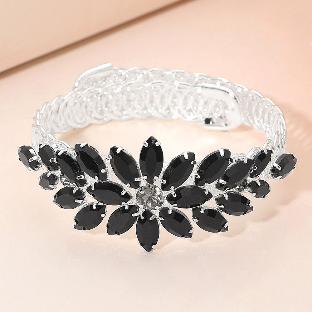 Black crystal floral adjustable bracelet on silver displayed on a beige background.