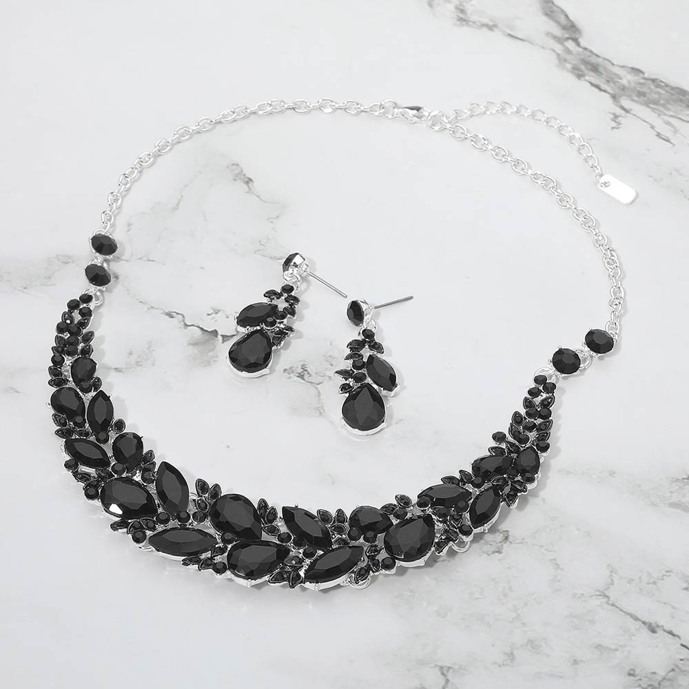 Black crystal statement necklace and earring set on silver featuring marquise stones for formal events on a marble background