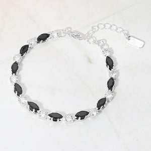 Black marquise crystal prom bracelet on silver on white marble background