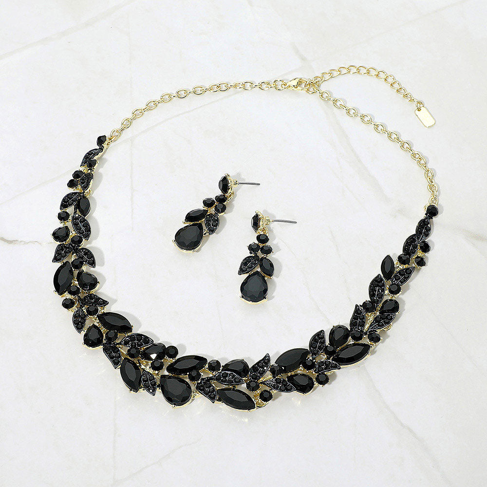 Small black marquise and teardrop crystal cluster formal necklace set on gold with matching earrings on white marble background