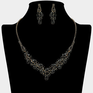 Black teardrop rhinestone necklace set with V-shaped crystal design and matching earrings, all backed in gold, for prom and formal wear. Shown on a black mannequin bust.  
