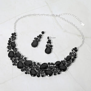 Black teardrop leaf branch statement necklace set on silver on a white marble background