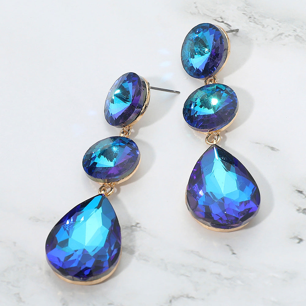 Blue AB teardrop and round crystal cluster earrings for interviews, pageants, or evening glam on a marble background