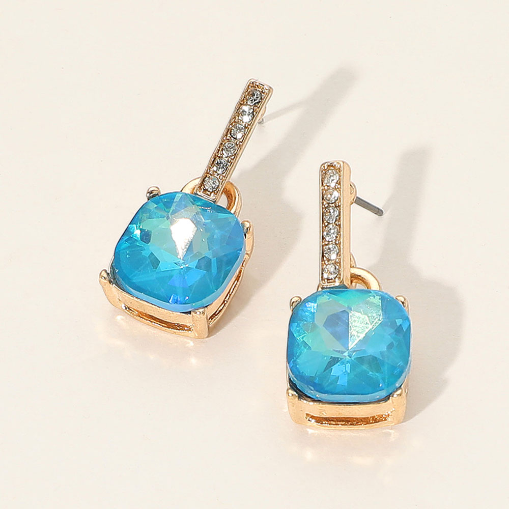Blue crystal cushion square dangle earrings on gold with a large cushion-cut stone suspended from a narrow crystal-lined bar, displayed on a white background.