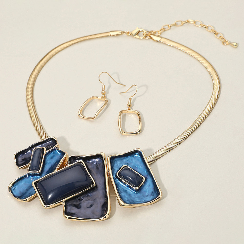 Blue geometric enamel beaded necklace set with matching earrings for prom or evening fashion. It is on an ivory background.