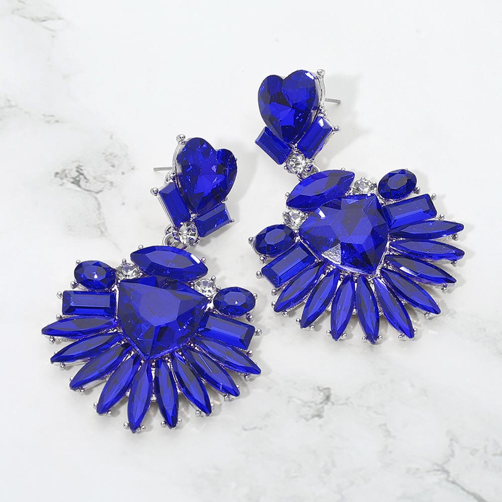 Sapphire-Royal Blue Heart Crystal Fan pageant and prom earrings on silver displayed on a white marble background