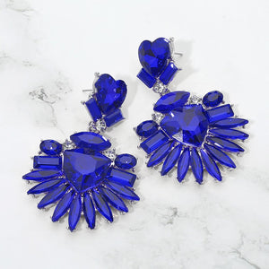 Sapphire-Royal Blue Heart Crystal Fan pageant and prom earrings on silver displayed on a white marble background
