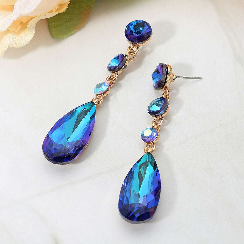 Blue rhinestone multi stone dangle earrings with teardrop crystal for pageant or prom on a white background