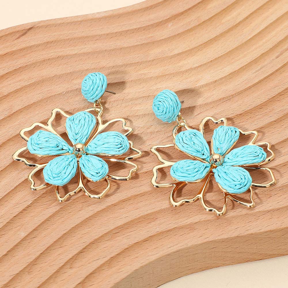 Blue raffia floral petal dangle earrings with boho statement style for runway, pageant outfit of choice, or everyday fashion with wooden background