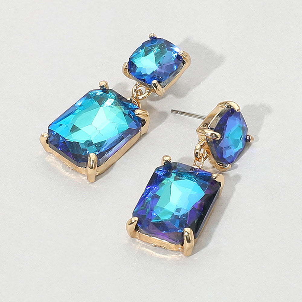 Blue gemstone earrings with gold accents on a light gray background