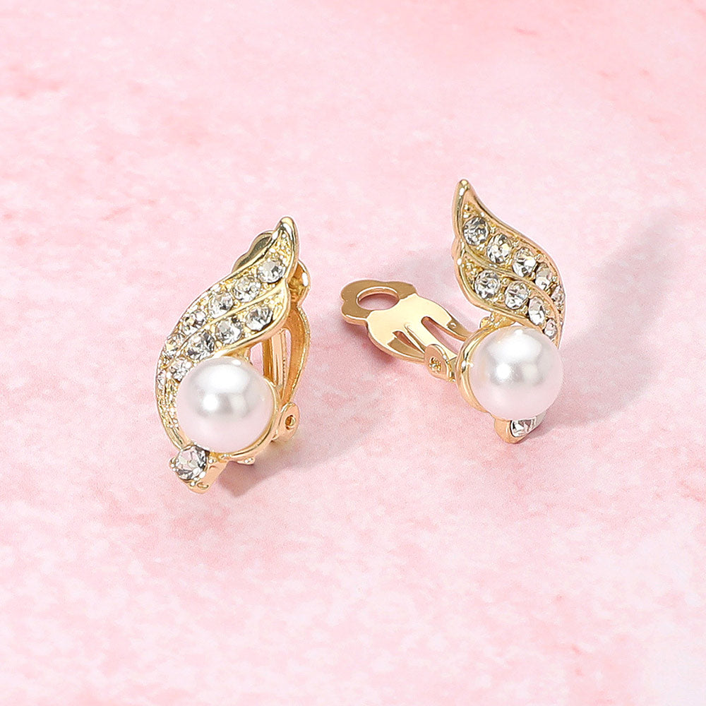 Bridal pearl and rhinestone wave clip-on earrings on gold for wedding, prom, or mother-of-the-bride style on a pink background
