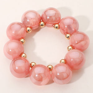 Chunky pink iridescent balls/spheres bracelet on a white background