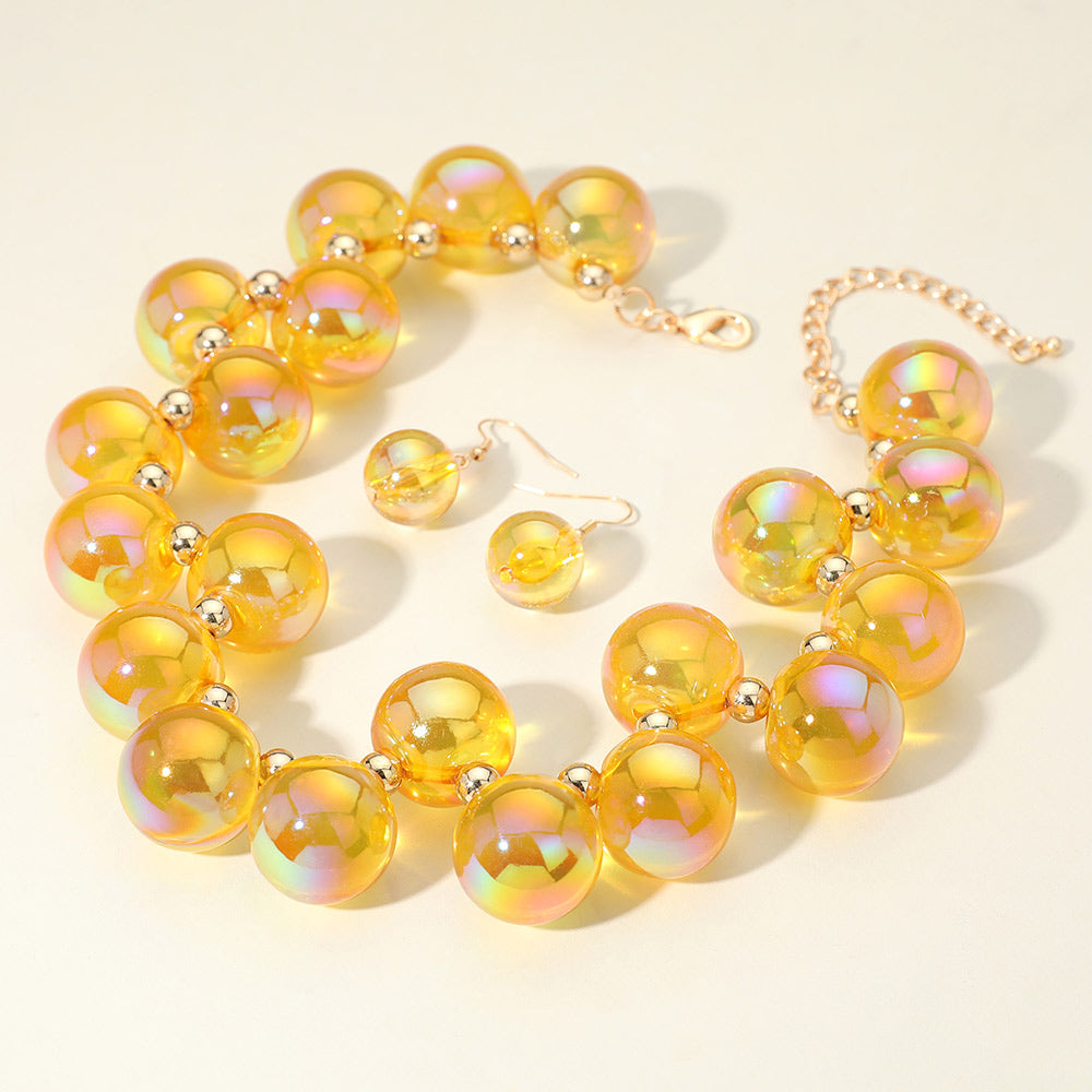 Chunky yellow iridescent balls/spheres necklace with matching earrings on a white background