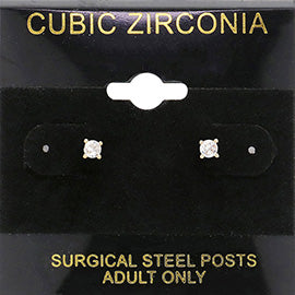 Classic round clear crystal stud earrings in a gold finish with prong settings and surgical steel posts, displayed on a black jewelry card.