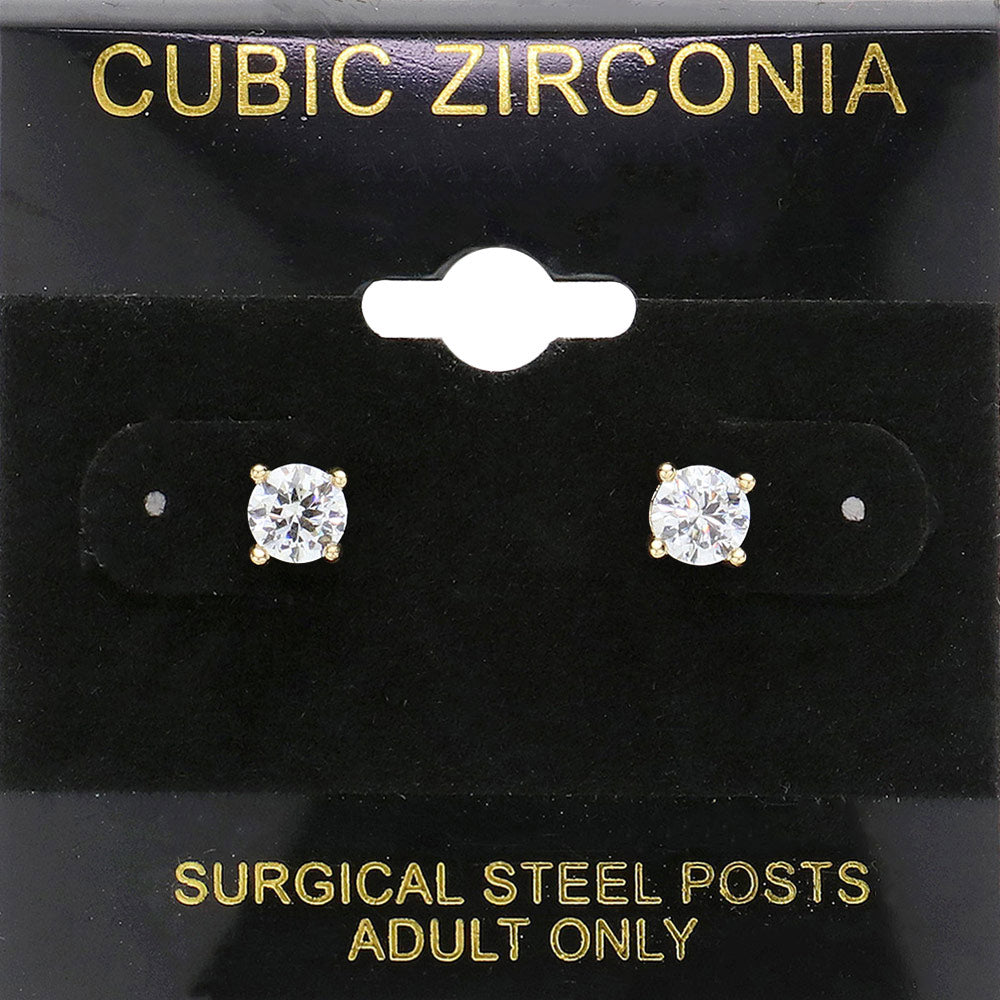 Classic round clear crystal stud earrings in a gold finish with prong settings and surgical steel posts, displayed on a black jewelry card.