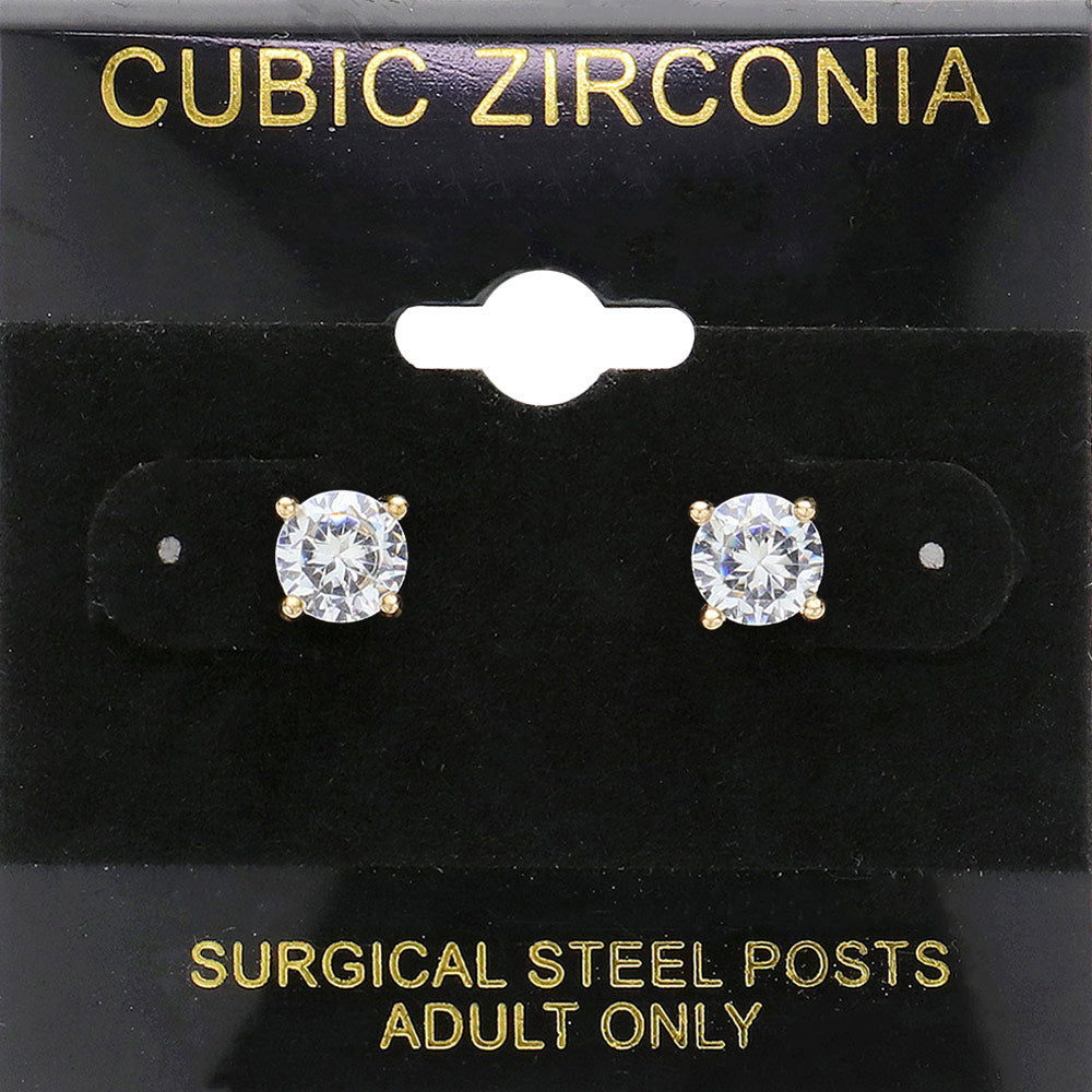 Classic round clear crystal stud earrings in a gold finish with prong settings and surgical steel posts, displayed on a black jewelry card.