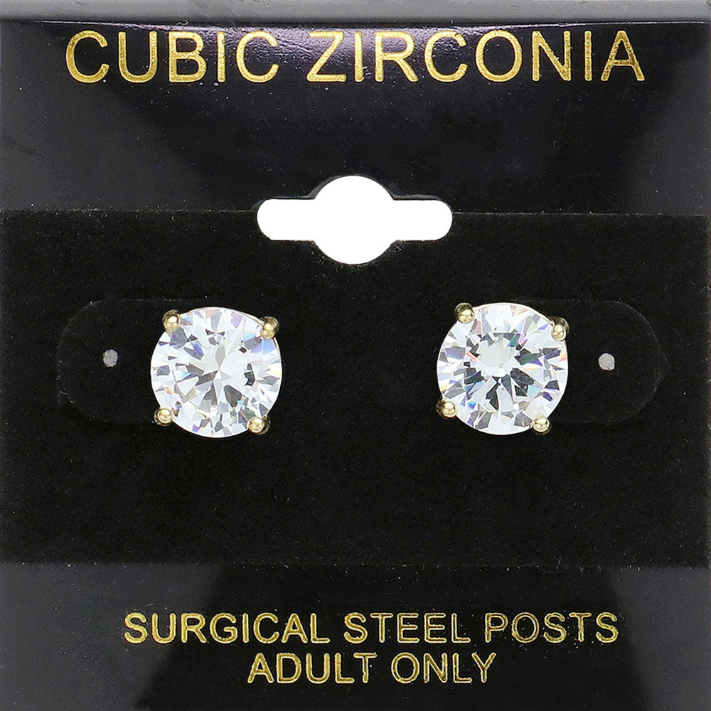 Classic round clear crystal stud earrings in a gold finish with prong settings and surgical steel posts, displayed on a black jewelry card.