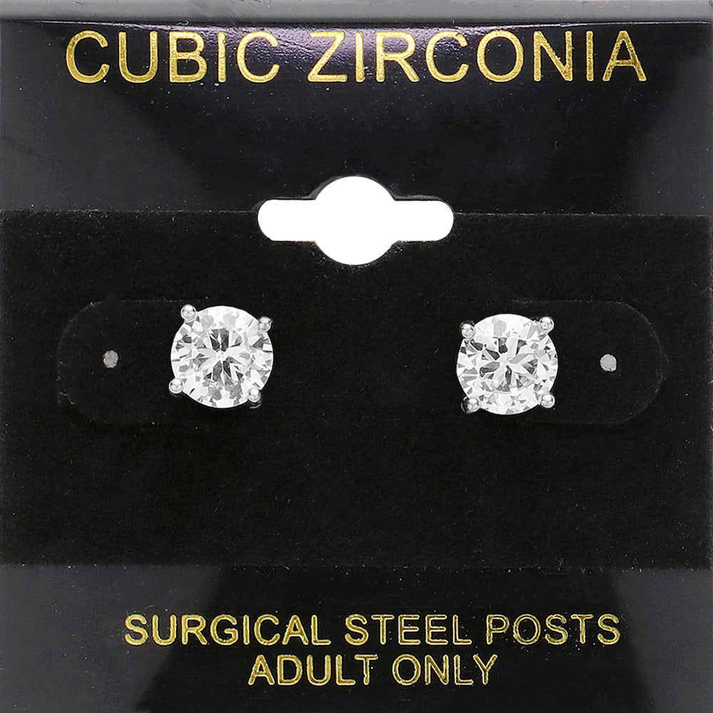 Classic round clear crystal stud earrings in a silver finish with prong settings and surgical steel posts, displayed on a black jewelry card.
