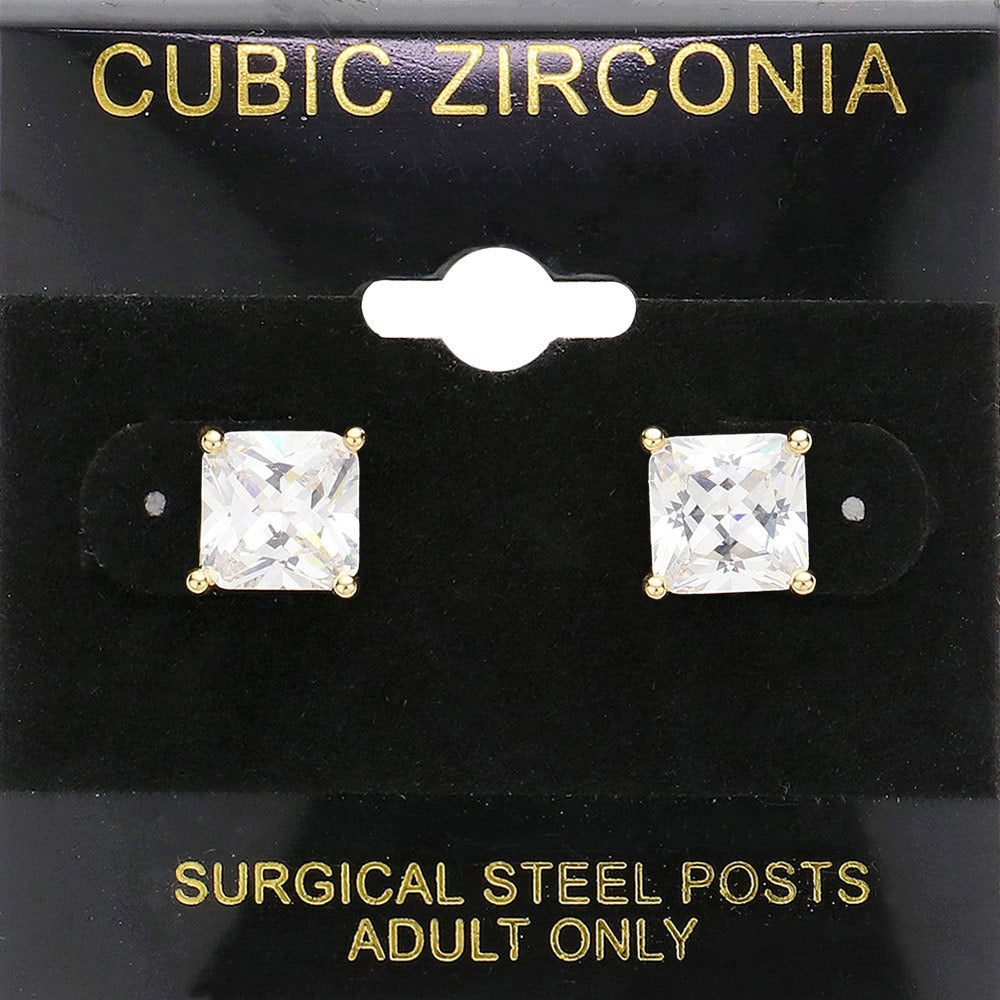 Classic square clear crystal stud earrings in a gold finish with four-prong settings and surgical steel posts, displayed on a black jewelry card.