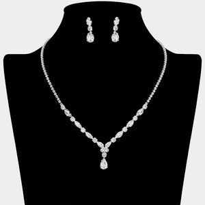 Clear crystal dainty necklace set on silver with spaced crystal accents, a delicate center drop, and matching drop earrings, displayed on a black jewelry bust.