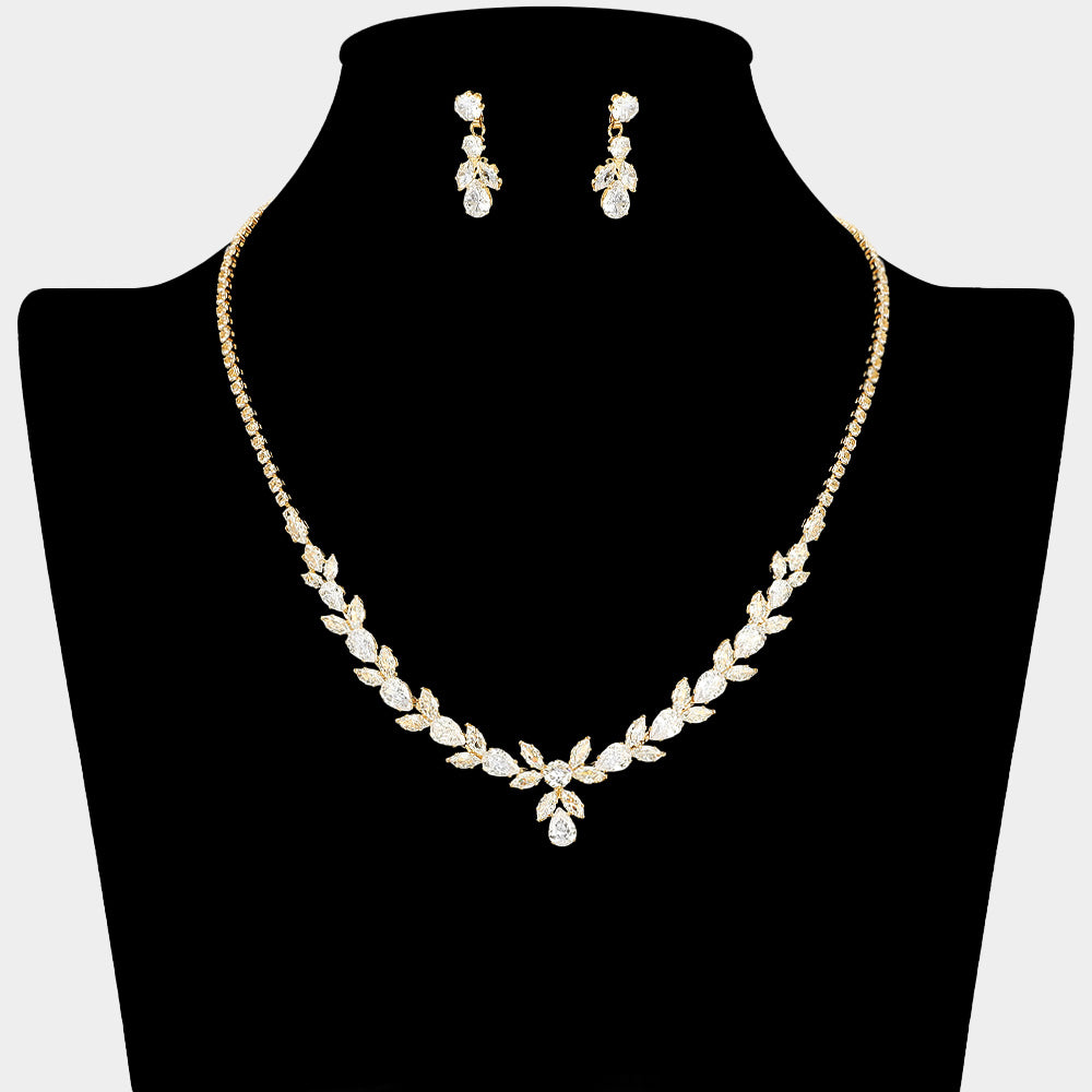 Clear crystal delicate necklace set on gold with alternating marquise stones, a small center drop, and matching drop earrings, displayed on a black jewelry bust.